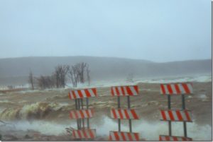 View of Devils Lake from highway 57 showing high waves and muddy water.